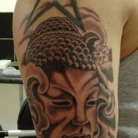 Buddhist face with buddhist symbols tattoo on arm