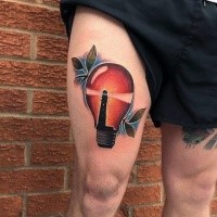 Bulb with lighthouse inside colored thigh tattoo with leaves and blue haze