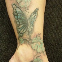 Tatuaggio colorato sulla gamba la farfalla con i fiori