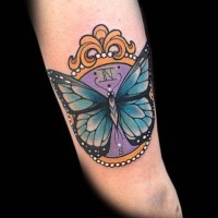 Tatuaggio colorato sul braccio la farfalla sull'orologio