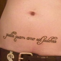 Tatuaje en vientre de una frase en latín