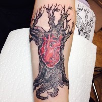 Carelessly painted colored big tree tattoo on forearm stylized with red human heart