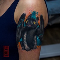Cartoon dragon tattoo on arm