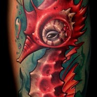 Cartoon like big red colored seahorse with creepy eye tattoo on sleeve