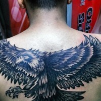 Cartoon like black and white detailed eagle tattoo on upper back