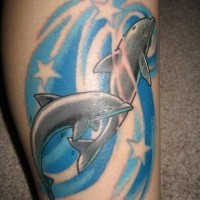 Cartoon like colored big dolphins with stars tattoo on leg