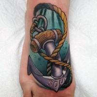 Cartoon like colored big roped anchor with lettering tattoo on foot