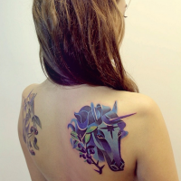 Tatuajes en el omóplato, cabeza de unicornio pequeño de color púrpura