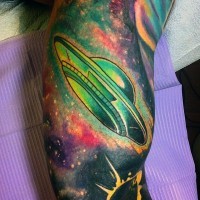 Cartoon like multicolored alien ship in space tattoo on arm