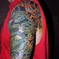 Cartoon like multicolored Godzilla tattoo on arm