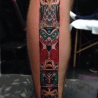Cartoon like multicolored tribal statue tattoo on leg