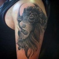 Cartoon style black and white shoulder tattoo of lion head