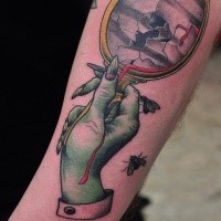Cartoon style colored arm tattoo of zombie arm with broken mirror
