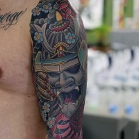 Cartoon style colored detailed Asian samurai warrior mask tattoo on shoulder with chrysanthemum