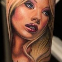 Cartoon style colored forearm tattoo of Barbie doll with lettering