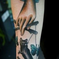 Cartoon style colored forearm tattoo of human hand with cat puppet and butterflies
