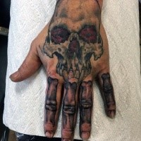 Cartoon Stil lustiger Vampir Schädel mit Knochen gefärbtes Tattoo an der Hand