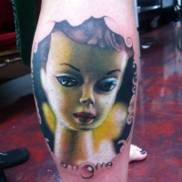 Cartoon style colored leg tattoo of doll face