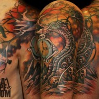 Tatuaje colorido en el hombro,
árbol mecánico extraordinario con reloj y cuervo