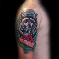 Cartoon style colored shoulder tattoo of raccoon with pie slice