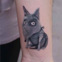 Cartoon style colored wrist tattoo of creepy dog