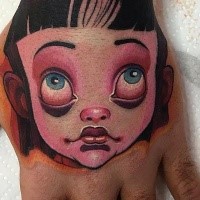 Cartoon style doll portrait tattoo on hand