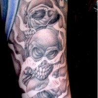 Cartoon style little mystical skulls tattoo on sleeve
