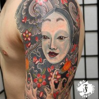 Cartoon style multicolored shoulder tattoo of Asian woman face with flowers