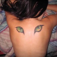 Coloured cat eyes tattoo on back