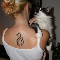 Cat shaped black ink upper back tattoo
