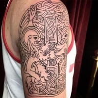 Celtic style black ink shoulder tattoo of of big cross and lions