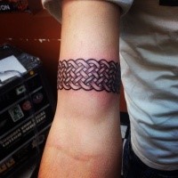 Tatuaggio bicipite colorato in stile celtico con bel braccialetto