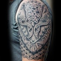 Celtic style colored shoulder tattoo of armor plate with emblem and lettering