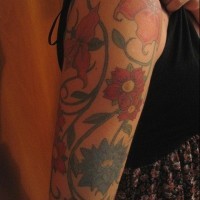 Tatuaje en el brazo,
flores de colores apagado