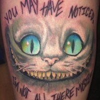 Tatuaje en el brazo, sonrisa del gato de cheshire, inscripción largo