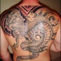 Tatuaje en la espalda,
dragón de cultura asiática con bola en garras