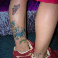 Tatuaje en la pierna, flores de color azul y mariposa hermosa