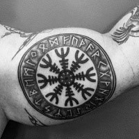 Circle shaped black ink biceps tattoo of ancient symbol with lettering