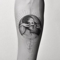 Circle shaped creative looking forearm tattoo of woman portrait