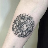 Eule auf blühendem Zweig im Kreis Tattoo am Unterarm mit Blumen