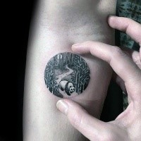 Circle shaped small tattoo stylized with night forest with panda bear