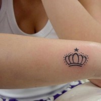 corona circondata e piccola stellina tatuaggio su braccio