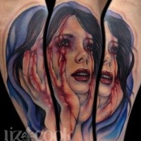 Colored creepy looking arm tattoo of bloody woman face