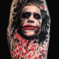 Colored evil Joker face tattoo with lettering