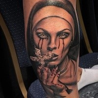 Colored horror style biceps tattoo of bloody woman with cross