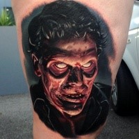 Colored horror style colored thigh tattoo of zombie face