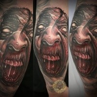 Colored horror style creepy looking arm tattoo of demonic face