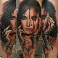 Colored horror style creepy looking bloody woman face tattoo on leg