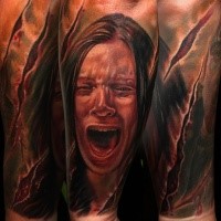 Colored horror style creepy looking forearm tattoo of screaming woman