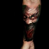 Colored horror style creepy looking forearm tattoo of colored demon